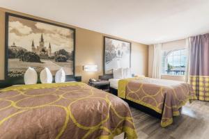 una camera d'albergo con due letti e una finestra di Super 8 by Wyndham Lake Charles Northeast a Lake Charles