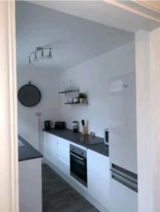 a white kitchen with a sink and a stove at Fieldside View, Contractors and Families in Doncaster