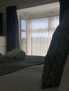 Schlafzimmer mit einem Bett und einem großen Fenster in der Unterkunft Fieldside View, Contractors and Families in Doncaster