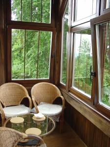 Habitación con sillas, mesa de cristal y ventanas. en Za bukiem, en Szklarska Poręba