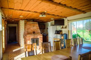 a kitchen with a brick fireplace and a dining table at Kivimaa Puhkemaja in Tiidu