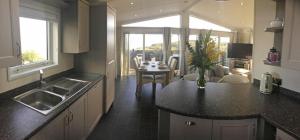 cocina con fregadero y mesa en una habitación en Sea View Lodge en Brixham