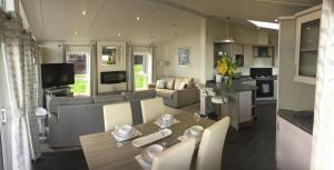 a living room with a couch and a table and a kitchen at Sea View Lodge in Brixham