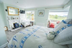a bedroom with a large bed in a room with a fireplace at Half Door House in Dingle