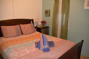 1 dormitorio con 1 cama con 2 zapatillas en Palmetto Guesthouse, en Culebra
