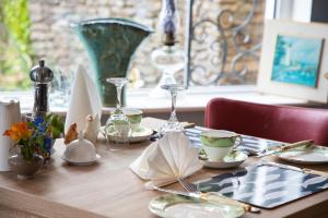 uma mesa de madeira coberta com pratos e chávenas sobre uma mesa em Half Door House em Dingle