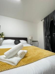 a bedroom with a bed with white towels on it at Wharf Inn Premier Apartment Central Manchester - Free Private Parking in Manchester