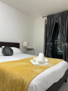 a bedroom with a bed with two towels on it at Wharf Inn Premier Apartment Central Manchester - Free Private Parking in Manchester