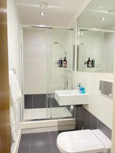 ein Badezimmer mit Dusche, Waschbecken und Toilette in der Unterkunft Wharf Inn Premier Apartment Central Manchester - Free Private Parking in Manchester + 17 Fotos