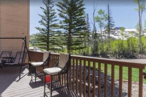 three chairs on a deck with trees in the background at Mountain Getaway and Pool at Brian Head Ski Resort in Brian Head