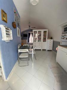una cucina con tavolo e parete blu di La Graziella monolocale Procidano a Procida