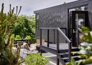 a black tiny house with a bench and a table at AutoCamp Cape Cod in Falmouth