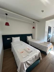 a room with two beds with white sheets and red lights at Kubi Hotel in Struga