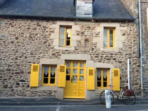 朗巴勒的住宿－CHAMBRE ROMANTIQUE CHEZ L'HABITANT à LAMBALLE，停在一座黄色门的建筑前面的自行车