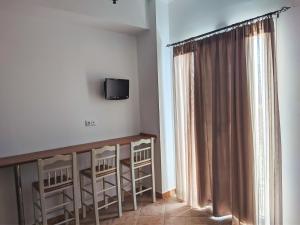 Chrysiis House 2 في Analipsi: غرفة مع تلفزيون وطاولة مع كراسي