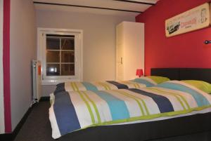 1 dormitorio con cama y pared roja en La Doyenne, en Francorchamps