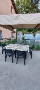 een grote picknicktafel met 2 stoelen en een grote parasol bij Melaaj Hill in Sarajevo
