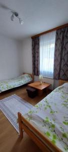 1 Schlafzimmer mit 2 Betten, einem Tisch und einem Fenster in der Unterkunft Melaaj Hill in Sarajevo