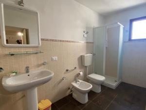 La salle de bains est pourvue d'un lavabo, de toilettes et d'une douche. dans l'établissement Agriturismo Il Melograno, à Cannizzara