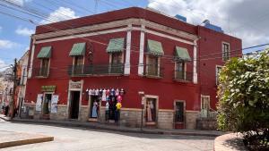 un edificio rosso sul lato di una strada di CAPITAL O Meson De La Fragua a Guanajuato