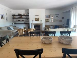 a living room with a wooden table and chairs at Mountain Beach House in Cascais