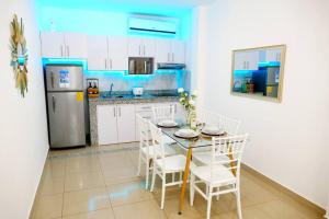 a kitchen with a table and chairs and a refrigerator at Ecusuites Playas House VI Resort Altamarll Piscina Playa in Playas