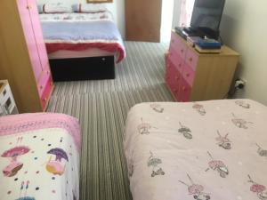 Postel nebo postele na pokoji v ubytování PINK HOUSE ,Opposite Beach ,SLEEPS 6 , 2 BEDROOM GROUND FLOOR SELF CONTAINED GARDEN FLAT , PRIVATE ENTRANCE , KITCHEN , Guaranteed Parking ,Wifi , Movies ,Bathroom ,fridge , microwave ,BEDROOM 1, DOUBLE BED & 2 SINGLE BEDS ,BEDROOM 2 , DOUBLE BED
