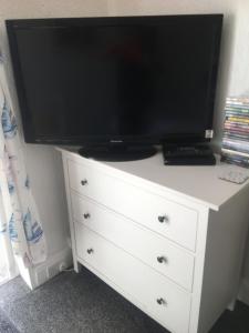 TV a/nebo společenská místnost v ubytování PINK HOUSE ,Opposite Beach ,SLEEPS 6 , 2 BEDROOM GROUND FLOOR SELF CONTAINED GARDEN FLAT , PRIVATE ENTRANCE , KITCHEN , Guaranteed Parking ,Wifi , Movies ,Bathroom ,fridge , microwave ,BEDROOM 1, DOUBLE BED & 2 SINGLE BEDS ,BEDROOM 2 , DOUBLE BED