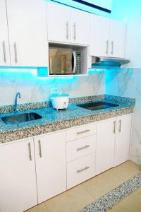 a white kitchen with a sink and a microwave at Ecusuites Playas House VI Resort Altamarll Piscina Playa in Playas