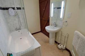uma casa de banho com um lavatório, um chuveiro e um WC. em Hafoty Farm Cottages em Caernarfon