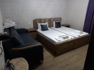 Habitación de hotel con cama y silla en Hotel Zaira, en Tiflis