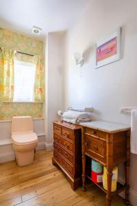 a bathroom with a toilet and a dresser and a sink at The Tallow Factory in Dedham in Dedham