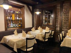 a restaurant with white tables and chairs and a bar at Landhotel Burkartsmühle in Hofheim am Taunus