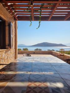 a large stone table on a patio with a view of the ocean at Villa Blu Majestic beach villa in Halki