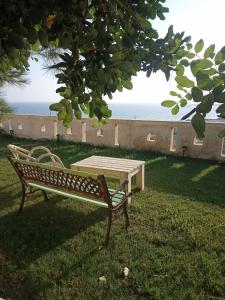 una panchina con un tavolo da picnic nell'erba di Agni apartment - Sunset in Blue a Ierápetra