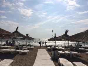 a beach with chairs and umbrellas and the ocean at Solaria House in Constanţa