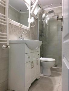 een witte badkamer met een wastafel en een toilet bij Solaria House in Constanţa