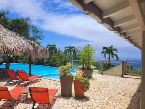 a patio with chairs and a swimming pool at Villa Dream in Deshaies