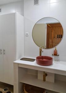 uma casa de banho com um lavatório vermelho e um espelho. em Flats 323 no Porto