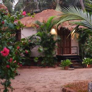 a small house with a thatch roof at Anahata Retreat Sea Front Resort Ashvem Goa in Mandrem