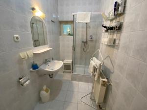 Un baño blanco con ducha y lavabo. en Villa Valeria Heviz, en Hévíz 33 fotos más