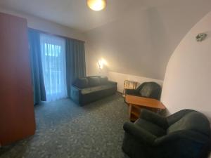 Una sala de estar con dos sillas y un sofá. en Villa Valeria Heviz, en Hévíz