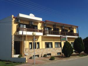 een geel gebouw met een balkon erboven bij Hotel Alos in Almyros