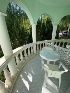 a white balcony with a table and chairs at Villa Valeria Heviz in Hévíz