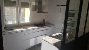 cocina con armarios blancos, fregadero y ventana en Apartamento Vadillos - VuT 09-401 en Burgos