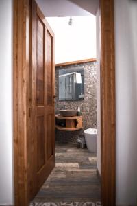 a bathroom with a wooden door and a sink at B&B Casa Martino SEA VIEW in Vietri