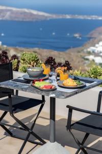 Una mesa con dos platos de comida encima. en Nimbus Santorini, en Oia