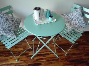 una mesa y 2 sillas con una mesa azul y 2 almohadas en La Vie En Rose, en Buia