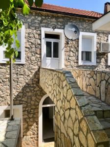 une maison en pierre avec une porte blanche et un escalier en pierre dans l'établissement Vila Razic, à Danilovgrad