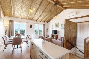 een keuken en een woonkamer met een tafel en stoelen bij Villa Feax Ocean View in Ereikoússa
